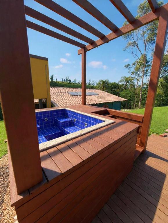 a deck with a swimming pool with a pergola at Chalé Manancial in Socorro
