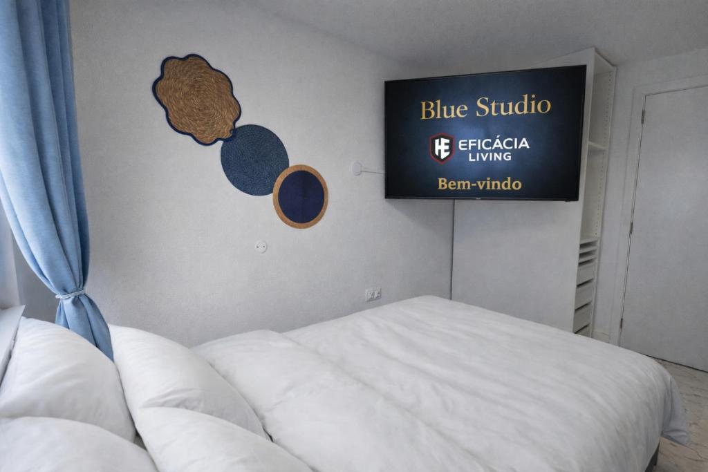 a bedroom with a bed and a sign on the wall at Blue Studio - Cozinha Privativa - Eficacia Living Abrantes in Abrantes