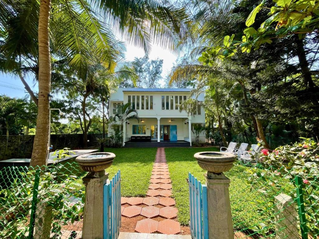 a white house with a fence and a yard at La Maison Bougainvillea in Mahabalipuram