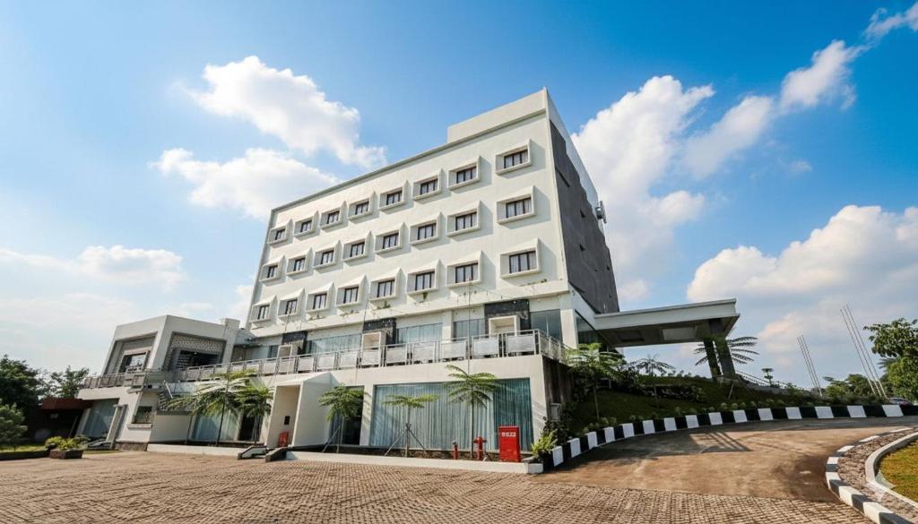 a white building with palm trees in front of it at Lakeside TELL Cikarang in Ceper 2