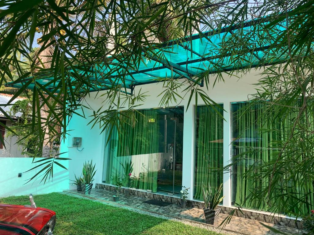 a house with a blue and white facade at Nomin Villa in Kottagoda