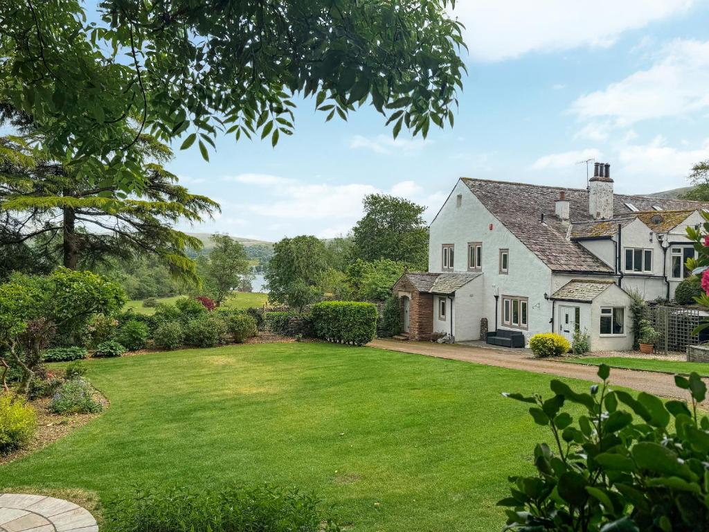 an exterior view of a white house with a yard at Barn End in Watermillock