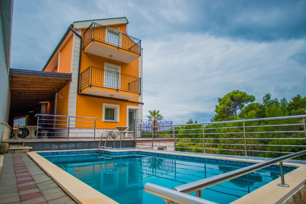une maison avec une piscine en face d'un bâtiment dans l'établissement Apartments Nina, à Promajna