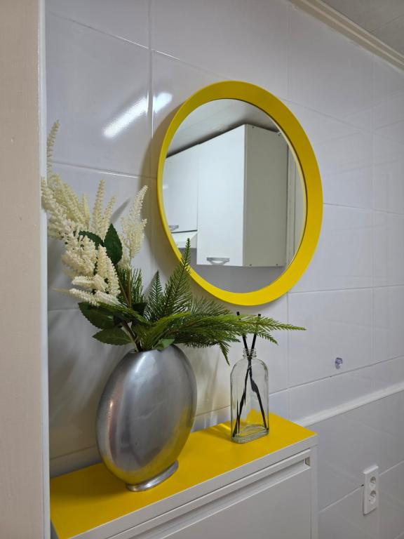 a mirror and a vase on a yellow table at dalcom kunkuk in Seoul