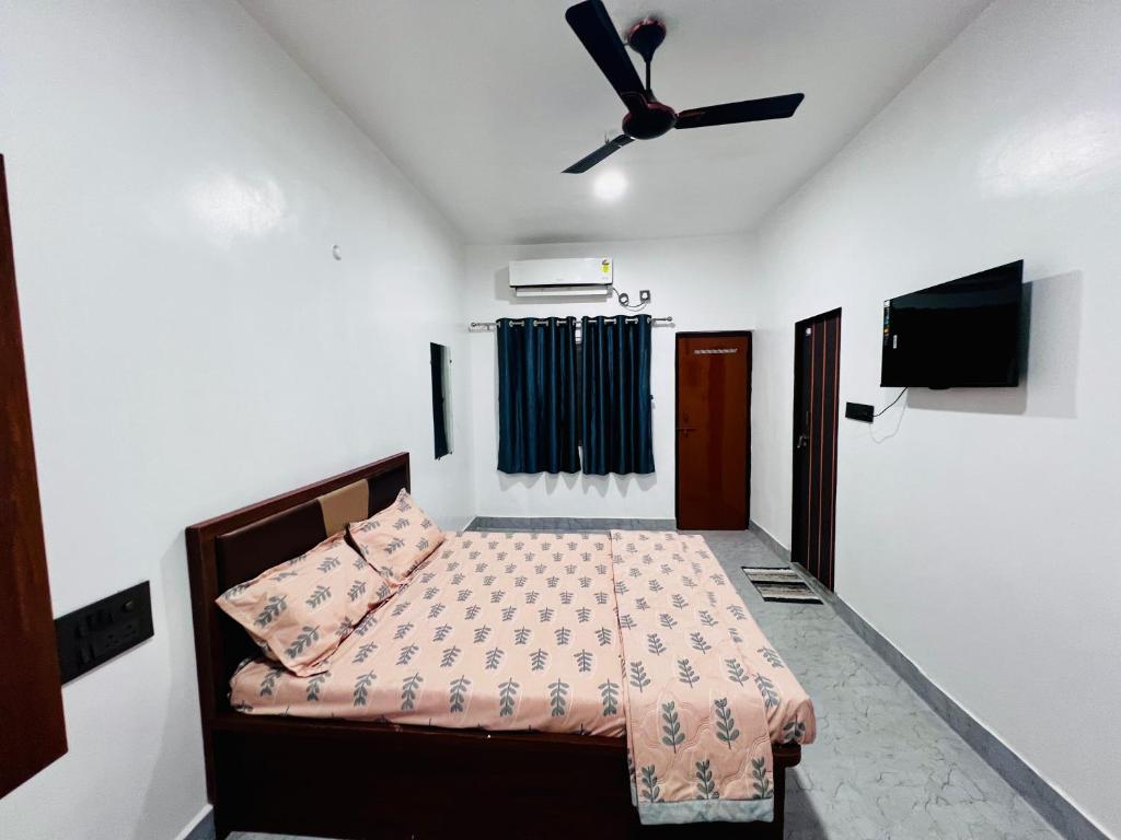 a bedroom with a bed and a ceiling fan at Sai Lodge in Ale