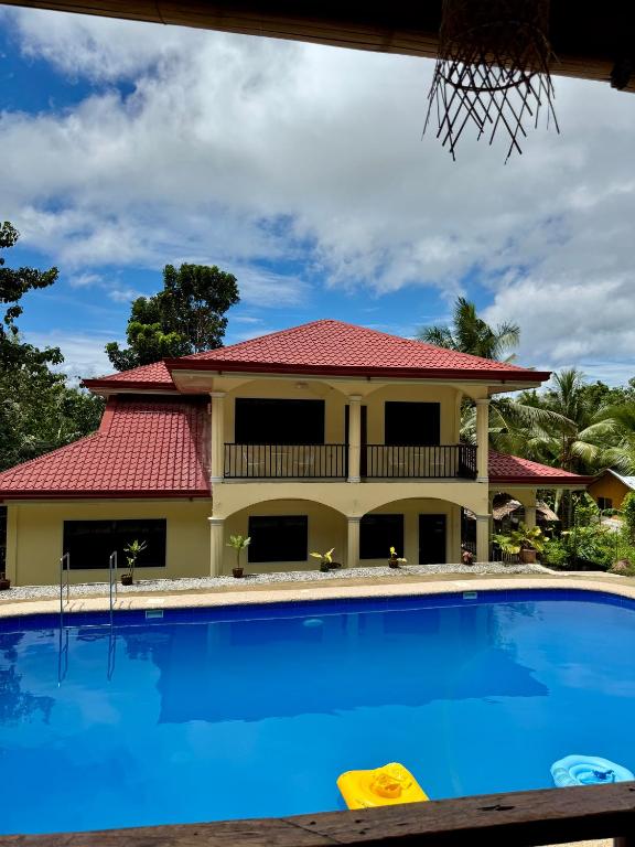 a house with a swimming pool in front of it at Villa Nicolasa in Siquijor