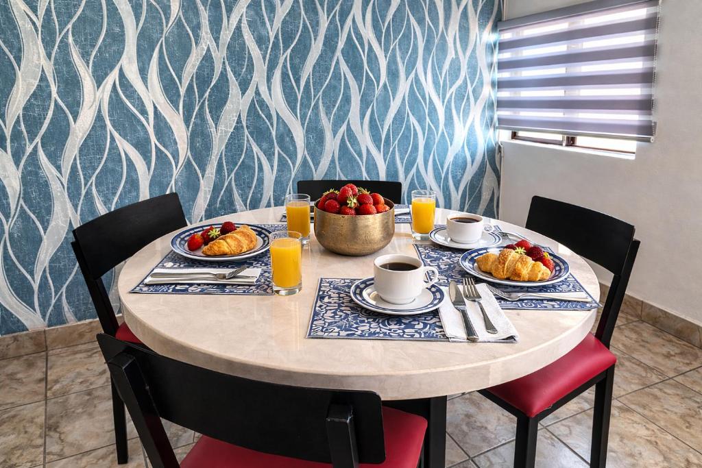 a table with two plates of food and a bowl of fruit at Suite moderna para 2, a 5 min del Centro in Ciudad Victoria