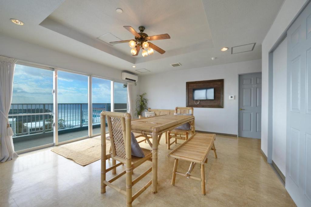a dining room with a table and views of the ocean at Sea Side TOYA in Yomitan
