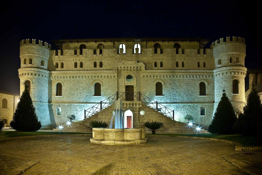 a castle at night with a staircase leading up to it at Hotel Castello di Septe in Mozzagrogna