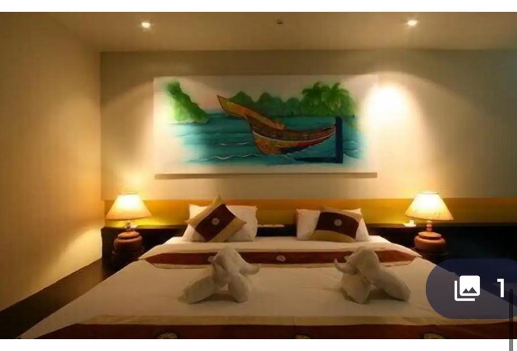 a bedroom with a bed with a painting on the wall at Aonang Cozy VIP in Ao Nang 