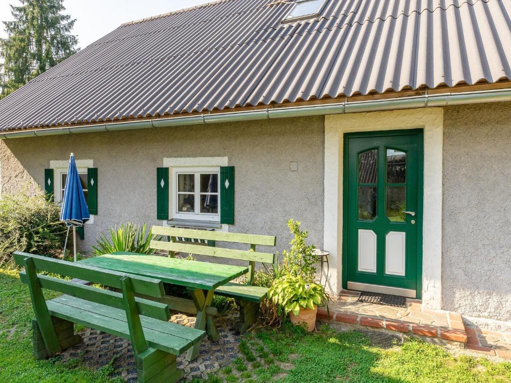 a picnic table in front of a house with a green door at Apartment in Styria near Grebenzen in Ligist