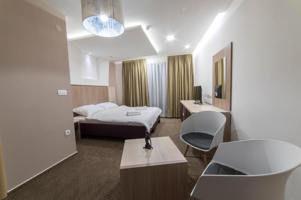 um quarto de hotel com uma cama e um lavatório em Patria Villa em Mostar