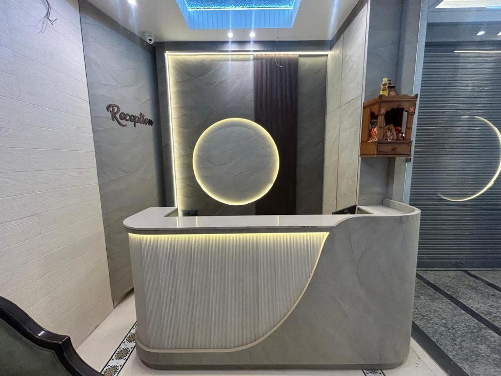 a lobby with a reception desk with a circle on the wall at Hotel Luxe in Kānpur