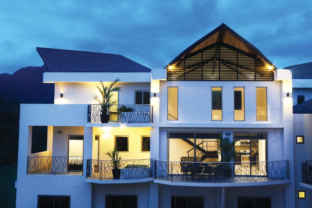 Casa blanca con balcón por la noche en SKY PENTHOUSES 3BR 3,5 BTH - 6BR 5,5BTH at OCEANO, en Jacó