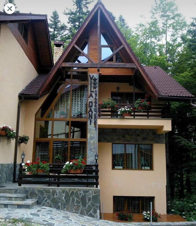 a large house with windows and flowers in front of it at Vila Dani in Sinaia
