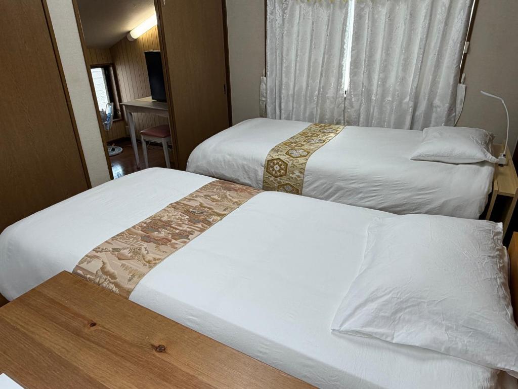 a hotel room with two beds and a window at 池袋House3F Cozy for 1-3 guests in Tokyo