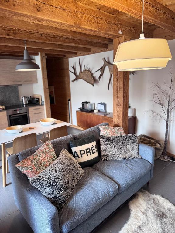 niebieska kanapa w salonie z kuchnią w obiekcie Chalet Moose w mieście Morzine