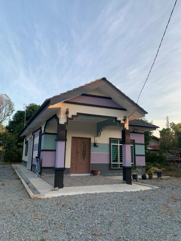 a small house with a brown door in a driveway at Homestay kampung moden in Pendang