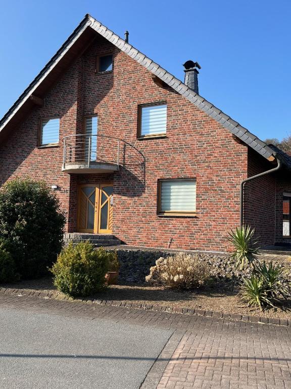 a brick house with a porch and a balcony at Ferienwohnung Fröse in Altenbeken