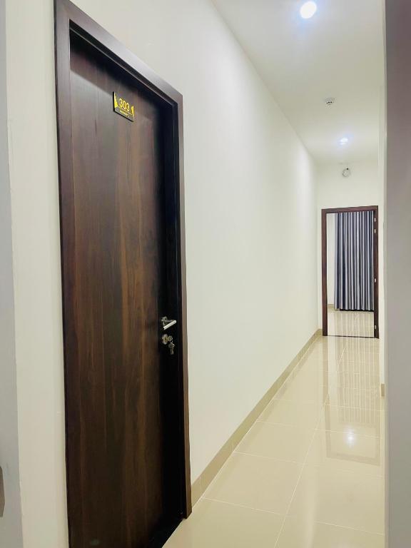 a wooden door with a sign on it in a hallway at Amazon Hotel in Phước Hậu (1)