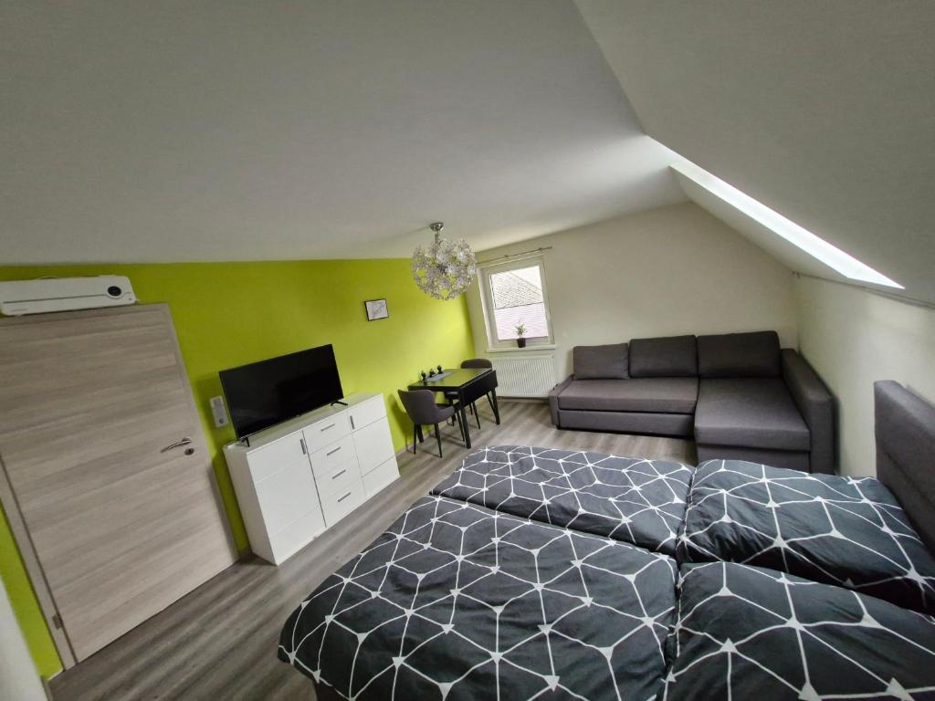 a bedroom with a bed and a couch and a table at Daniels Gästezimmer in Dockweiler