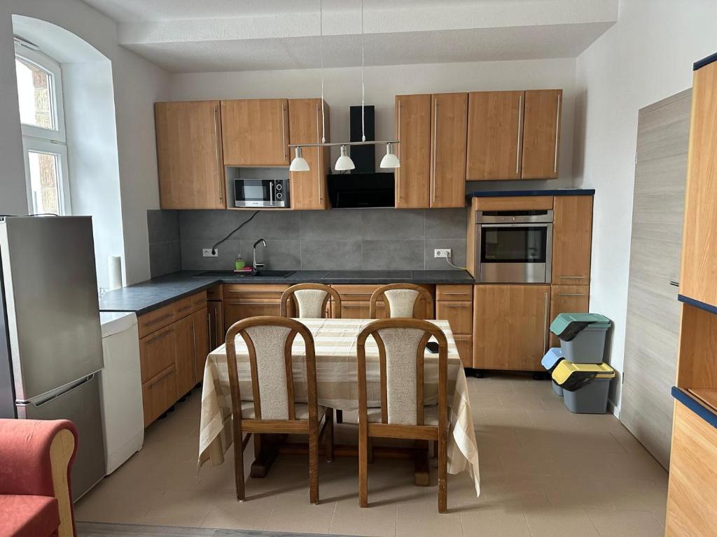 a kitchen with a table with chairs and a refrigerator at Appartement 3 in Diemelstadt 
