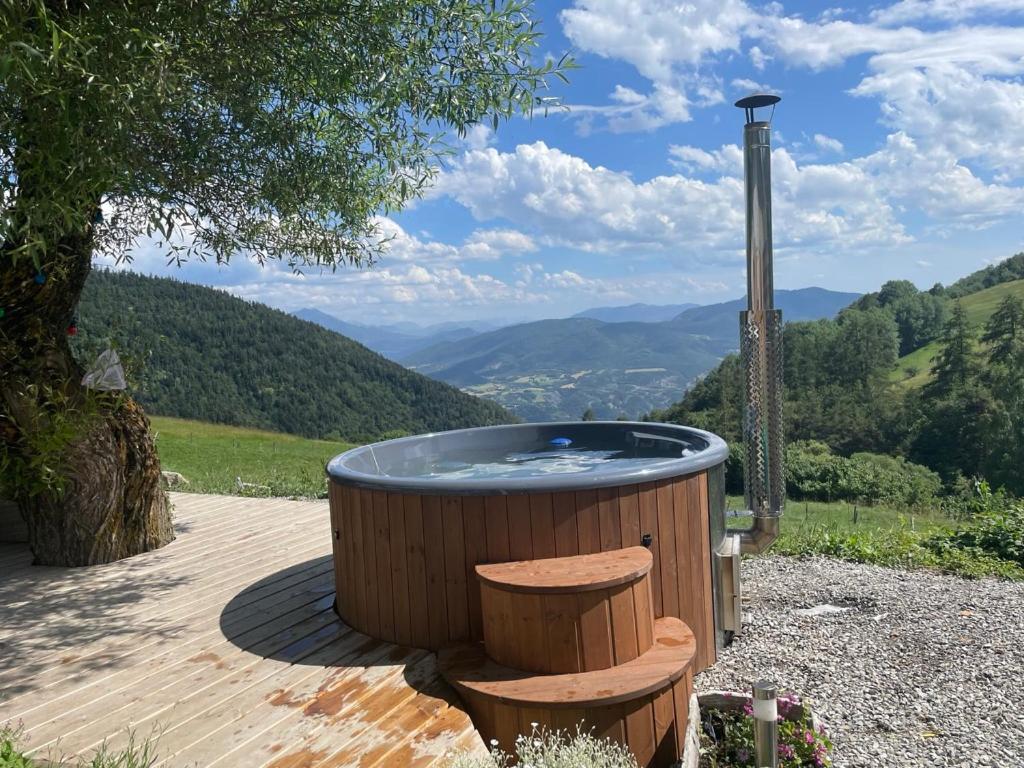 a hot tub on a wooden deck with a view of mountains at Forest d' ARTO in Ancelle