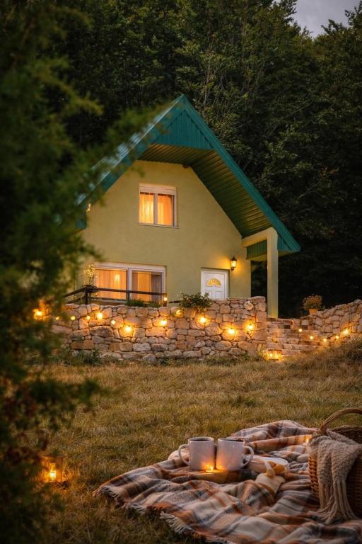 a blanket in front of a house with lights at Forest Panorama Cabin Brezna in Plužine