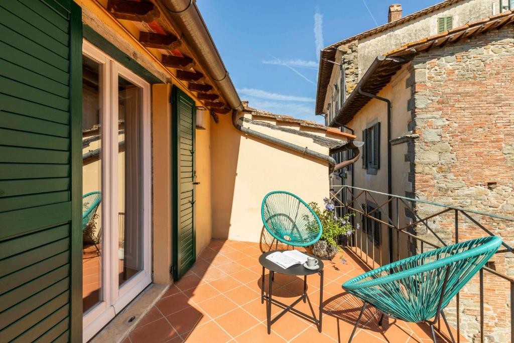 a balcony with two chairs and a table at Romantico appartamento nel centro storico in Cortona