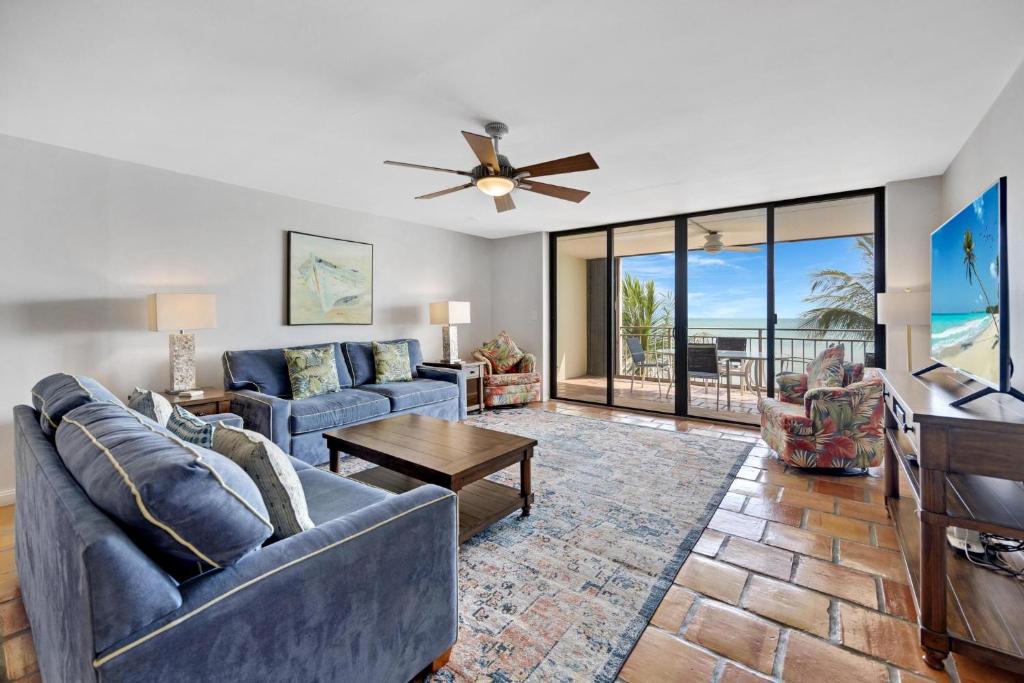 a living room with two blue couches and a table at Beach Club Oasis #304 in Key West