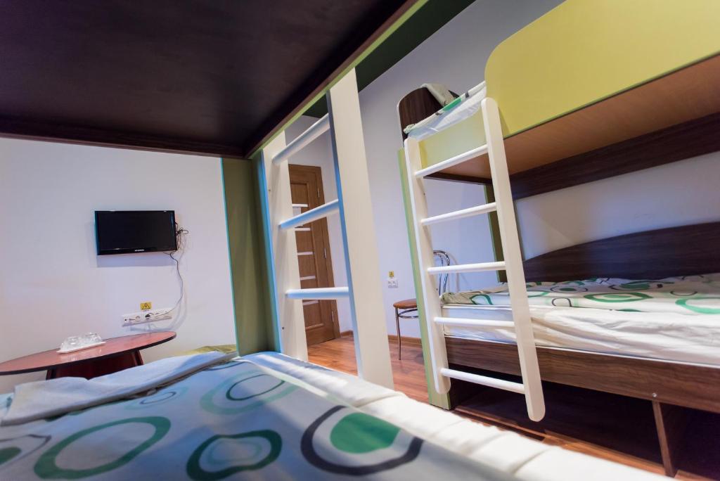 a bedroom with two bunk beds and a tv at Green Hostel in Sfântu-Gheorghe