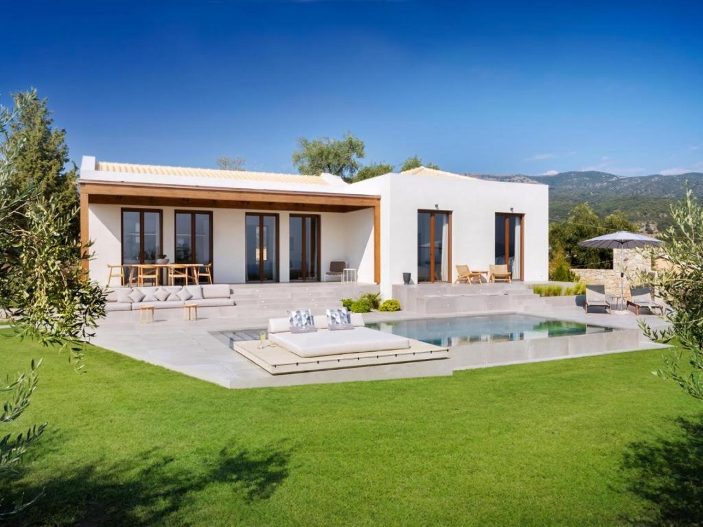 a villa with a swimming pool and a house at Villa Anthilia in Syvota