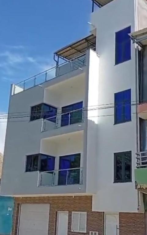 een wit gebouw met blauwe ramen bij Casa do Céu Azul in Tarrafal