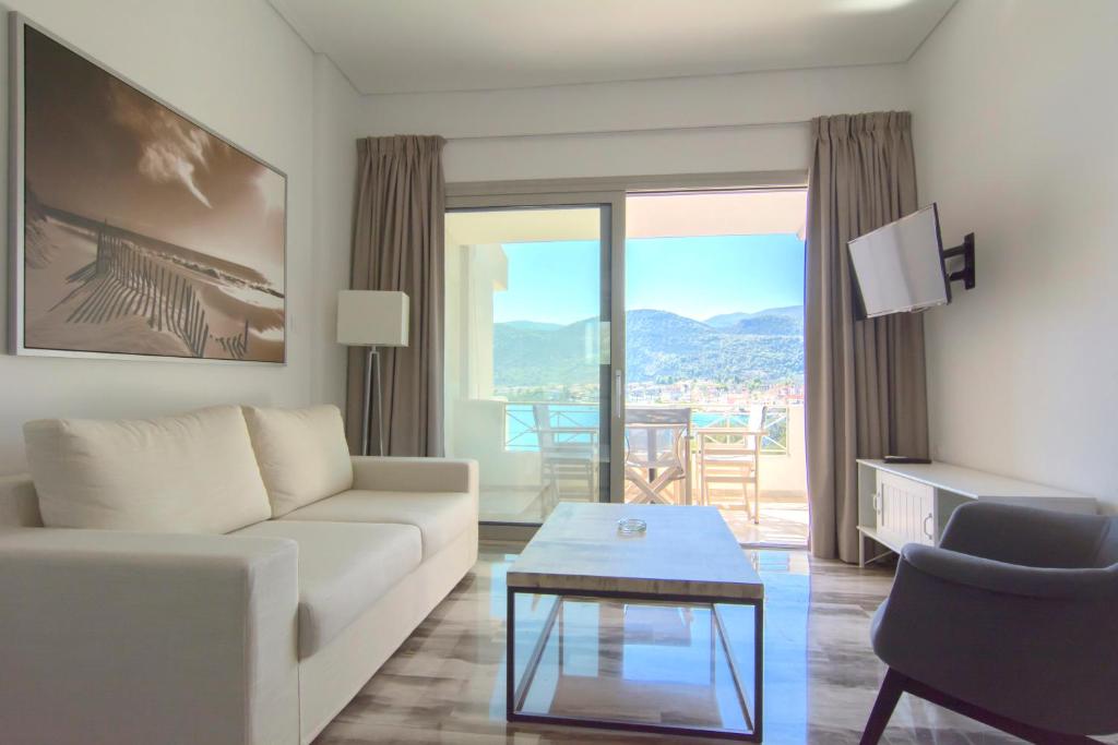 a living room with a white couch and a table at Belvedere Suites Korfos in Korfos