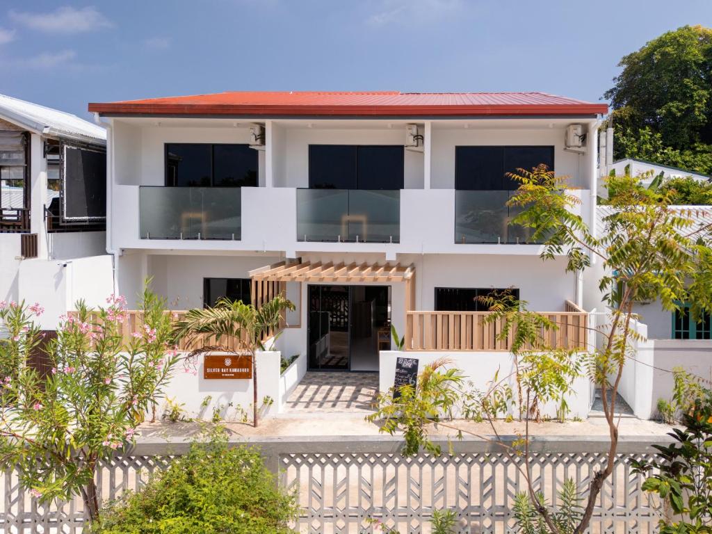 a white house with a fence in front of it at Silver Bay Kamadhoo in Kamadhoo
