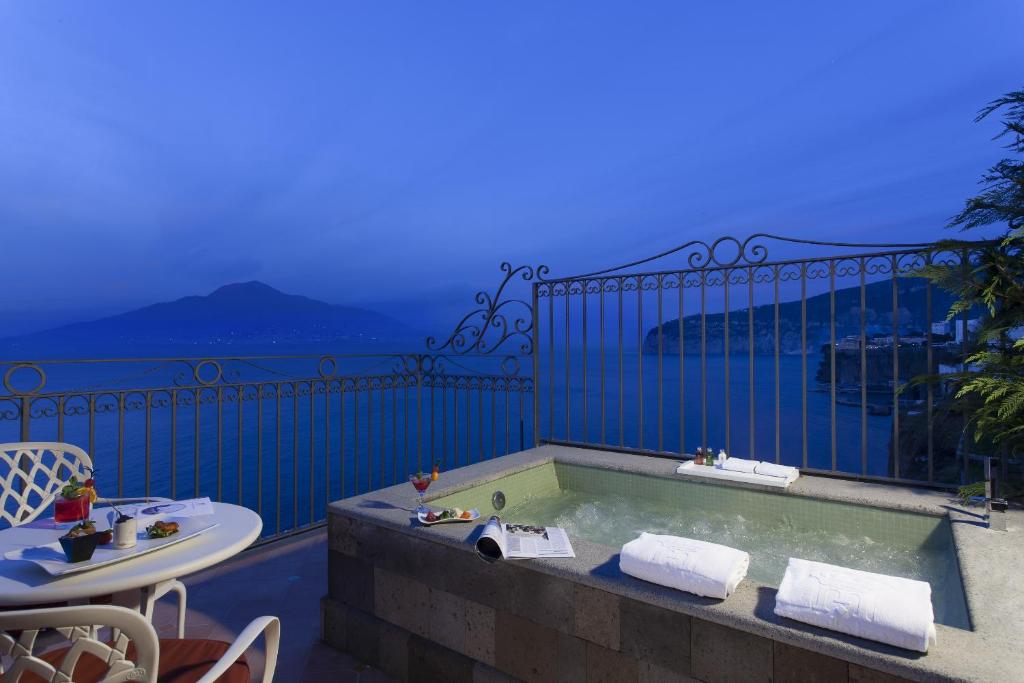 a bath tub on a balcony with a view of the ocean at Grand Hotel Ambasciatori in Sorrento