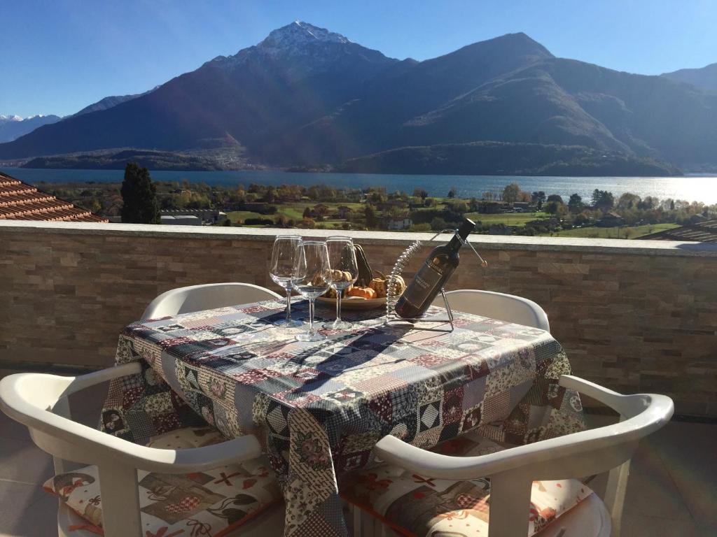 una mesa con una botella de vino y copas en el balcón en Al Borgo, en Gravedona