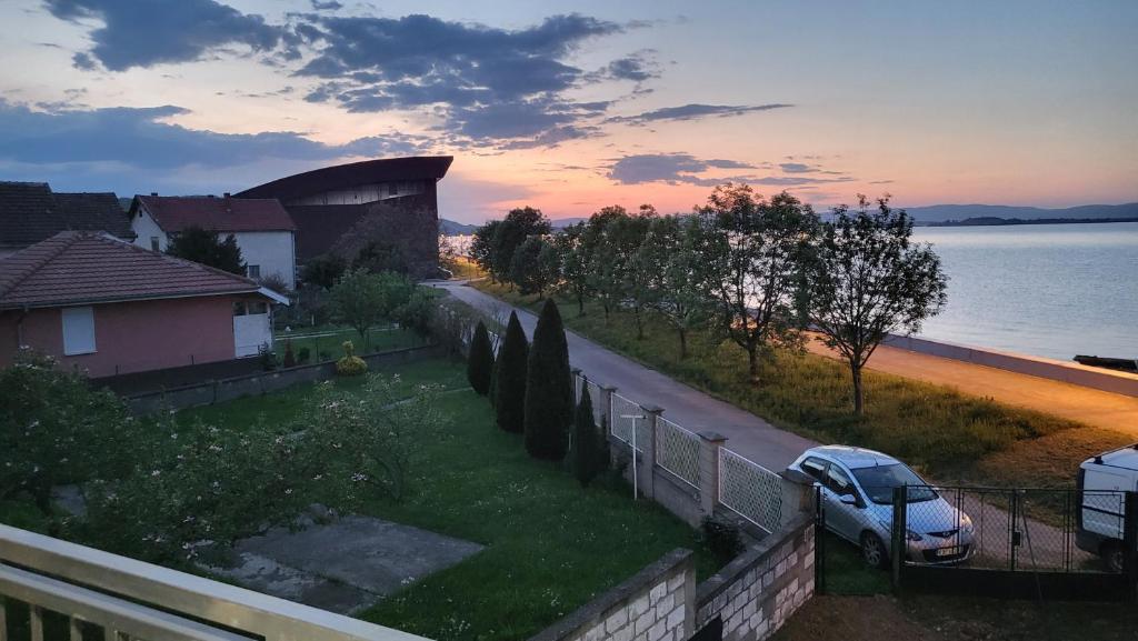 a car parked on the side of a road near the water at Miris Dunava 2 in Golubac