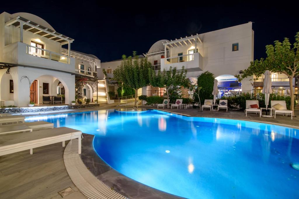 a swimming pool in front of a building at night at La Mer Deluxe Hotel & Spa in Kamari
