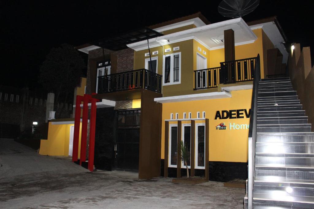 a yellow and black building with a red door at Adeeva Homestay Syariah in Wonosobo