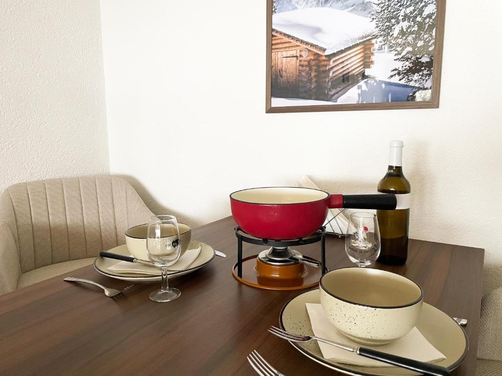 a table with a mortar and pestle on a table with wine glasses at Nendaz Alpine Studio - Ski & Swimming Pool in Nendaz