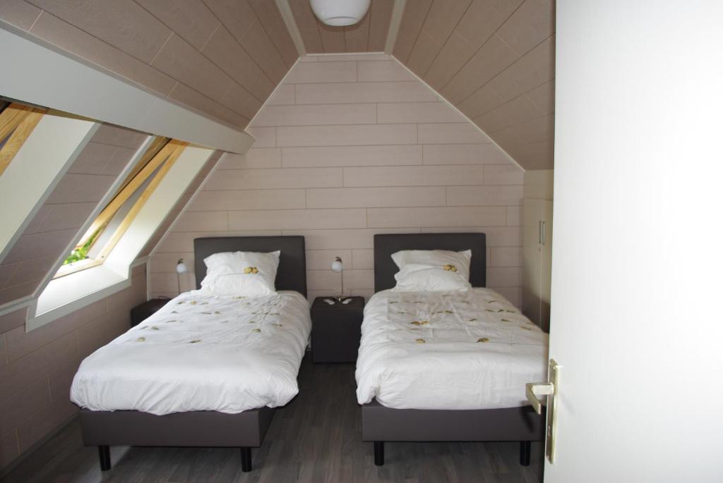 dwa łóżka w pokoju z dwoma oknami w obiekcie Gîte Horlitin w mieście Amougies