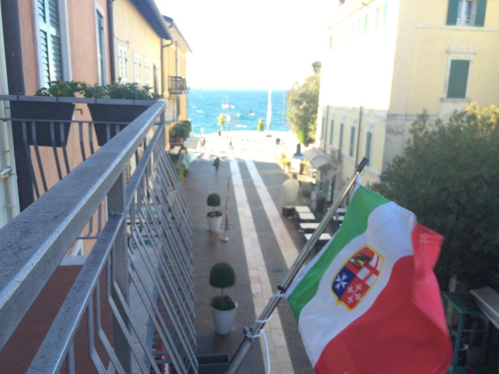una bandera está colgando en el balcón de un edificio en Appartamento Arco, en Lazise
