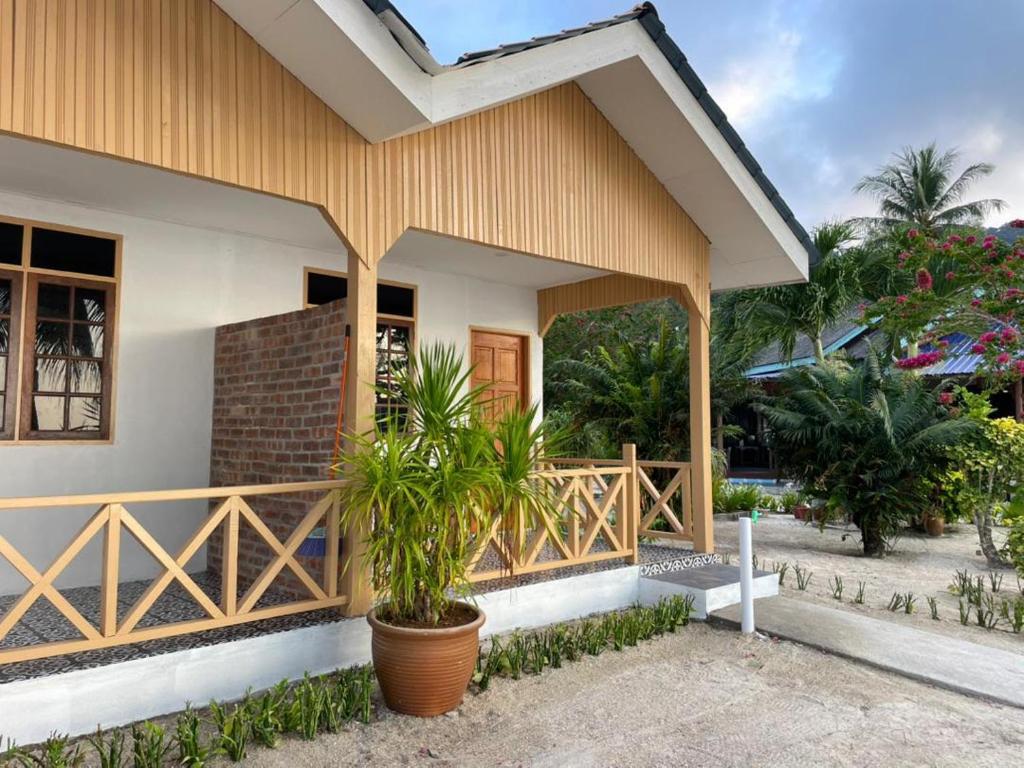 a house with a porch with a plant in front at Samudra Beach Chalet in Perhentian Islands