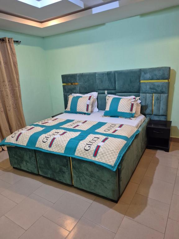 a bedroom with a bed with a blue bedspread and pillows at G and E Guesthouse in Kumba