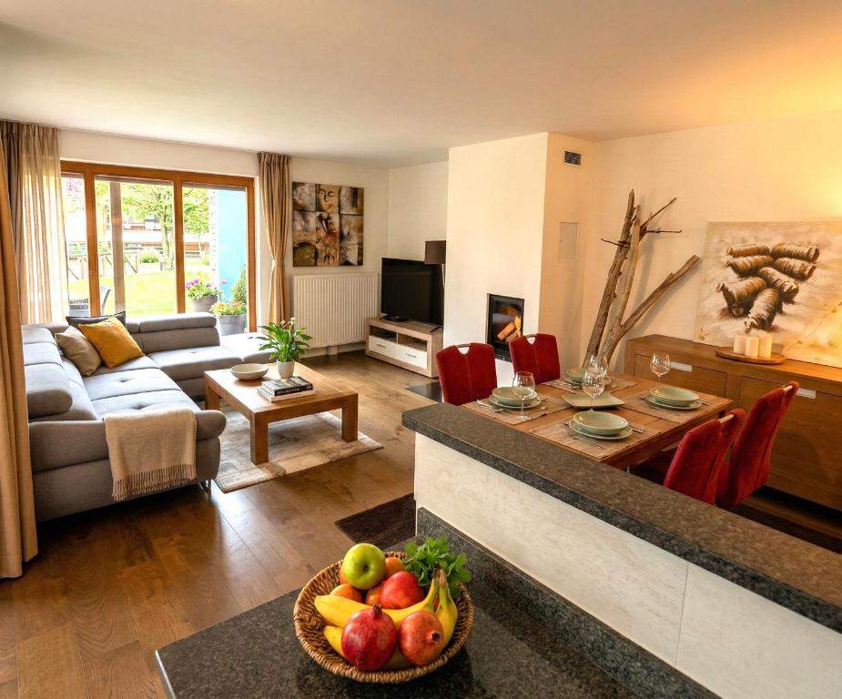a living room with a couch and a table with a bowl of fruit at Walensee Apartment, Lake & Alpine Dream in Unterterzen