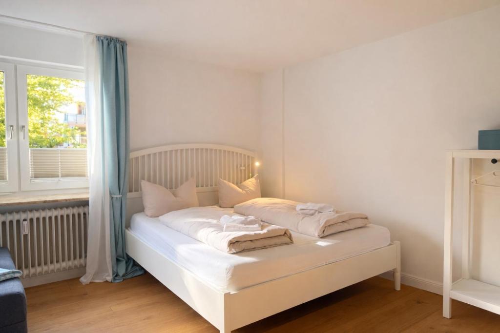 a white bed in a room with a window at Beachfront Studio - 1 Strandreihe in Scharbeutz