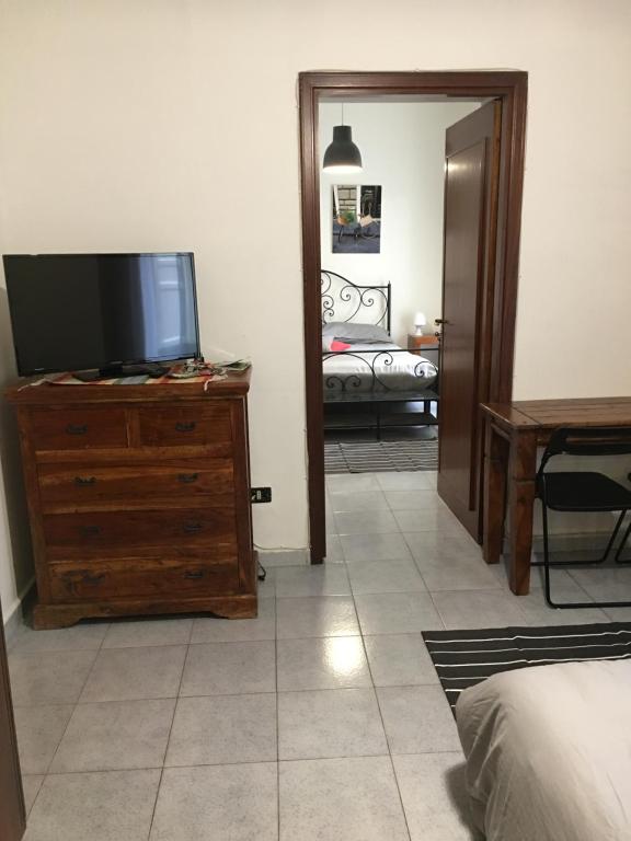 una camera da letto con TV a schermo piatto su un comò di Apartment Co a Palermo