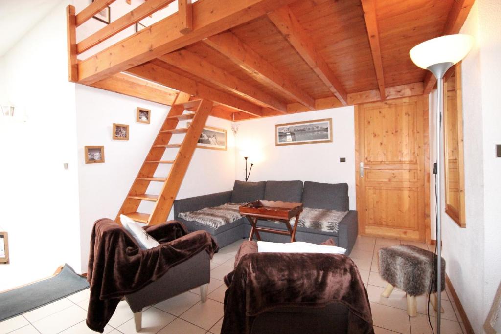 a living room with a couch and a staircase at Grande chaume 5.1 : Centre station, à 200m du télésiège in Les Deux Alpes