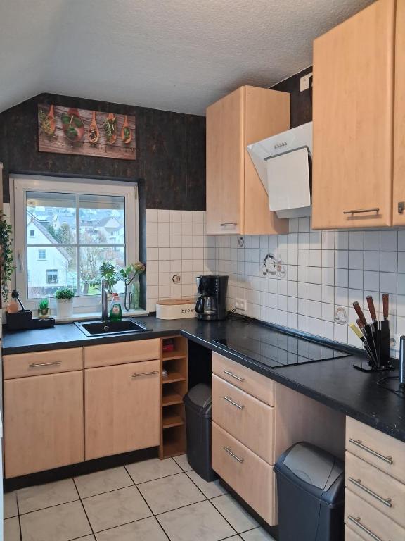 a kitchen with wooden cabinets and a sink and a window at Ferienwohnung Stefanie OG in Bad Breisig